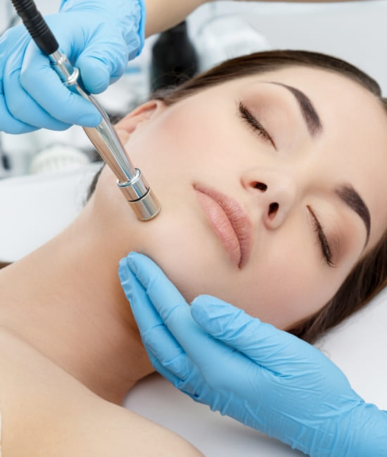 A young woman receiving a treatment of facial microdermabrasion