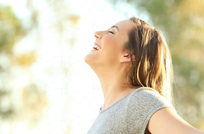 A woman smiling in joy as she feels relief from respiratory symptoms